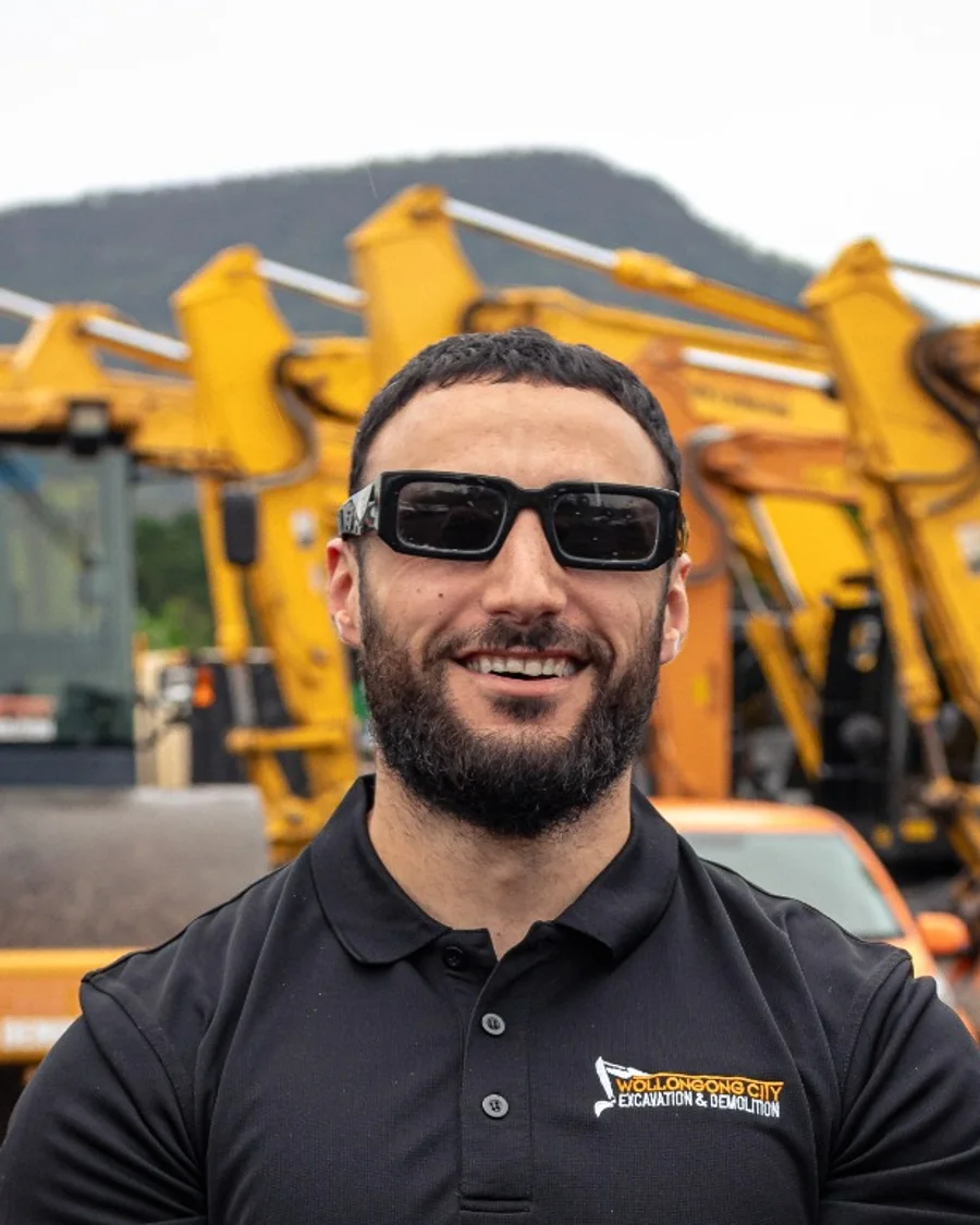 Mohammad, Client & Project Coordinator at WCED, in front of the WCED machinery fleet